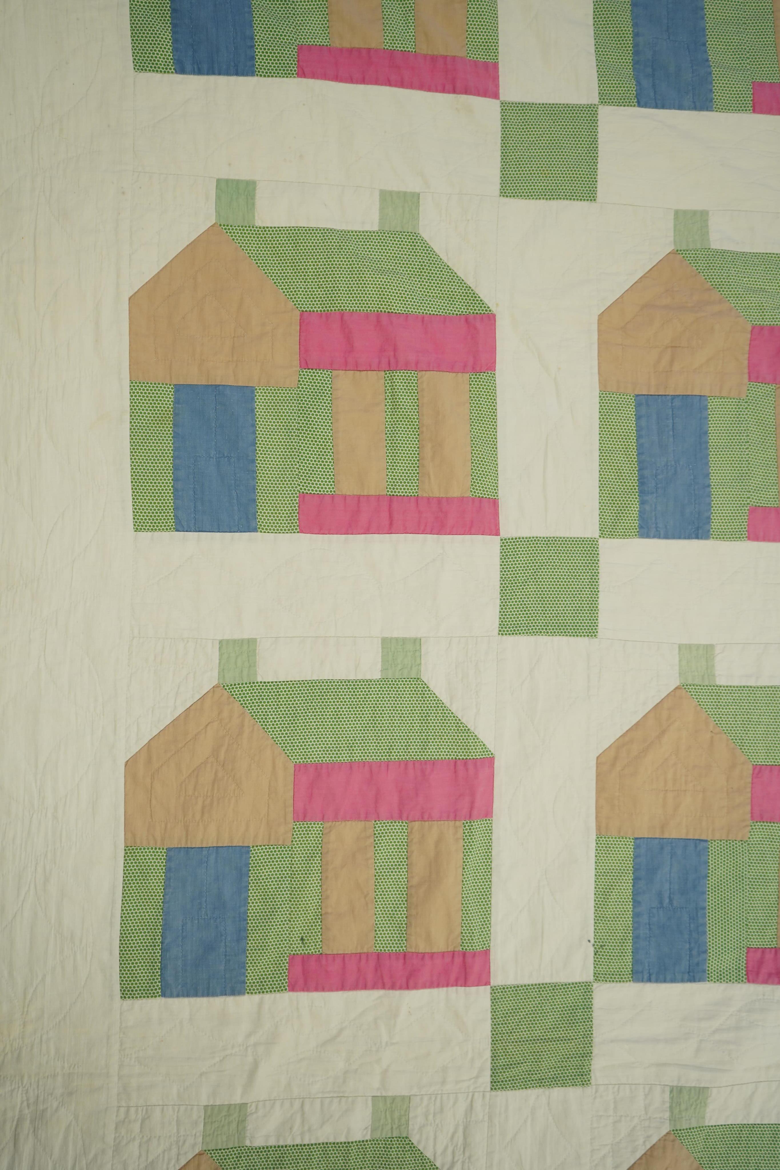 A 1930’s American quilt from Vermont. Quilted in large patchwork ‘house’ motifs, repeating the same four colours in each motif against a plain white background. The reverse a plain white quilted cotton . The quilt hand p